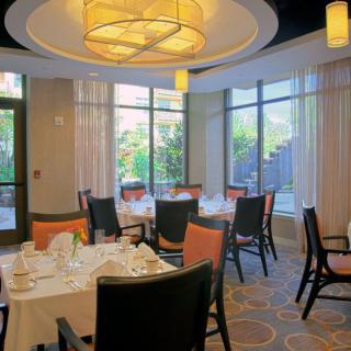 An elegantly set dining room with round tables and modern decor.