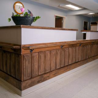 A modern reception area featuring a wooden desk with decorative elements.