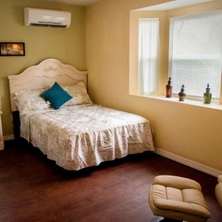 A cozy bedroom with a single bed and window seat.