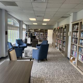 A cozy library with armchairs and bookshelves lining the walls.