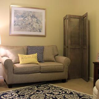 A cozy living room with a comfortable sofa, decorative pillows, and a patterned rug.