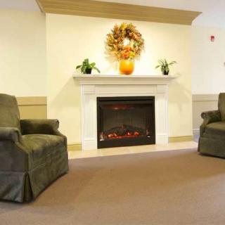 A cozy living room with a fireplace and two armchairs.