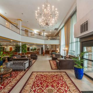 A luxurious hotel lobby featuring elegant chandeliers, sophisticated seating arrangements, and ornate carpets.