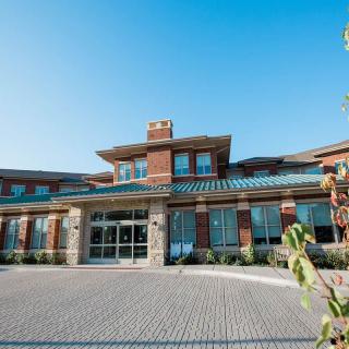 A modern brick building with a welcoming entrance and clear blue sky in the background.