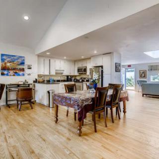 Spacious open-plan dining and kitchen area with modern decor and wood flooring.