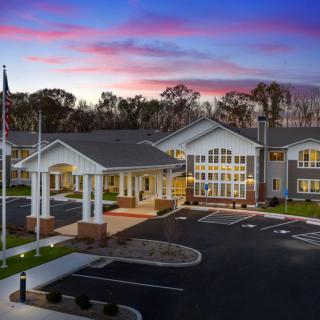 A building with an entrance and parking lot at sunset.