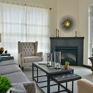 A modern living room featuring elegant furniture, a central coffee table, and a cozy fireplace.