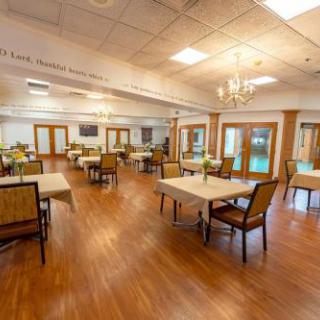 A spacious dining area with elegantly arranged tables and chairs, designed for comfort and social interaction.