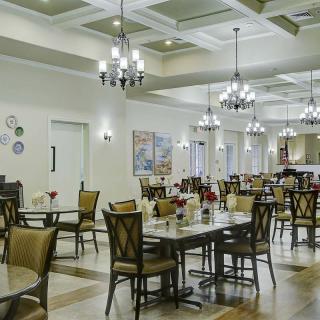 An elegant dining room with chandeliers and neatly arranged tables and chairs.