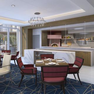 A modern restaurant interior with elegant seating and a visible kitchen featuring a wood-fired oven.