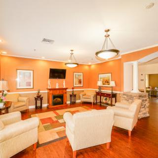 A cozy living room featuring warm orange walls and comfortable seating, perfect for relaxation and social gatherings.