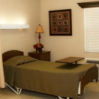 A simple hospital room with a bed and bedside table.