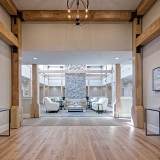 A modern lobby with wooden beams, a chandelier, and a comfortable seating area.