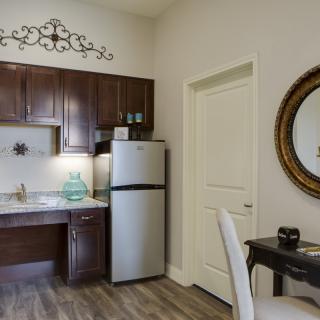 A modern kitchen and dining area with dark wood cabinets and a stainless steel refrigerator.