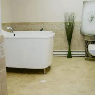 A modern bathroom featuring a sleek bathtub and a toilet with minimalist decor.