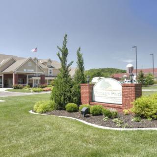 A landscaped area featuring a building and a sign surrounded by greenery.