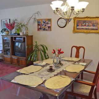 A cozy dining room with a set table, antique television, and decorative elements.