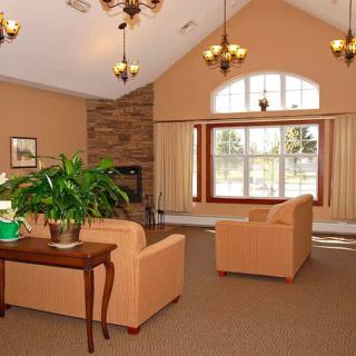 A cozy living room with sofas, a fireplace, and large windows.