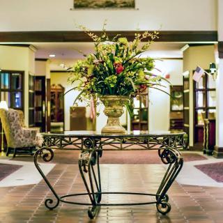A luxurious hotel lobby featuring a decorative table with an elegant flower arrangement.