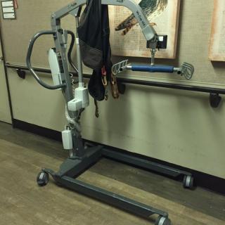 A patient lift used for assisting individuals with mobility challenges in a healthcare setting.