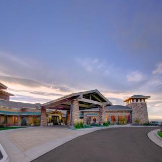 A modern building with a spacious driveway under a cloudy sky.