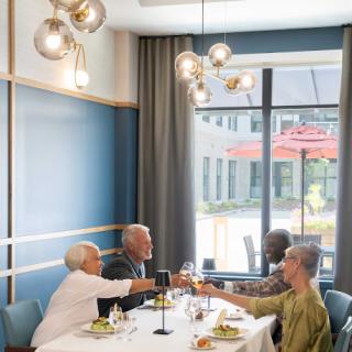 A joyful gathering of friends enjoying a meal together, raising their glasses in celebration.