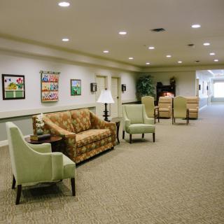 A well-lit hallway with seating and artwork on the walls.