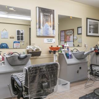 A clean and organized hair salon interior with washing stations and mirrors.