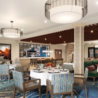 A modern restaurant interior featuring elegant chandeliers, tables, and chairs set for dining.
