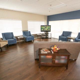 A spacious living room with comfortable seating, a television, and a wooden coffee table.