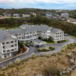Aerial view of a hotel surrounded by lush greenery and residential buildings.