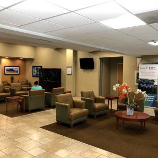 A comfortable waiting room with seating, a television, and decorative elements.
