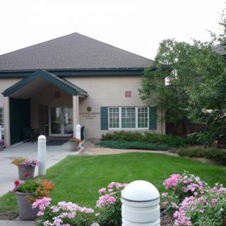 A well-maintained house with a beautifully landscaped garden featuring pink flowers.
