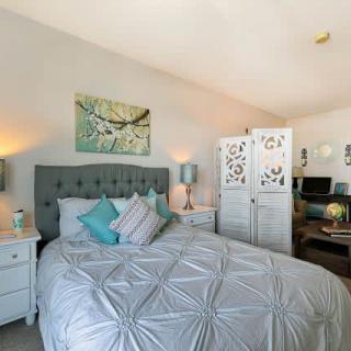 A cozy bedroom with a plush bed, decorative pillows, and elegant furnishings.