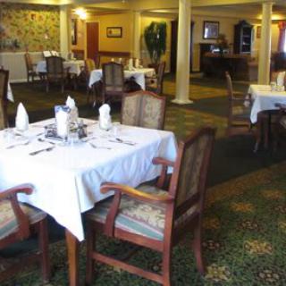 Cozy restaurant interior with elegantly set tables and chairs.