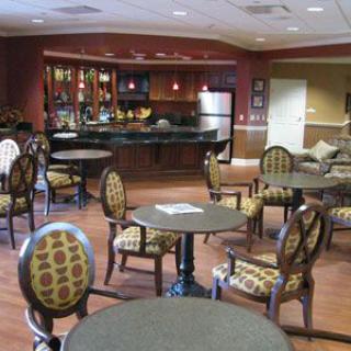 A cozy lounge area with tables, chairs, and a bar.