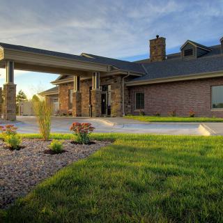 A modern brick house with well-maintained landscaping and a driveway.