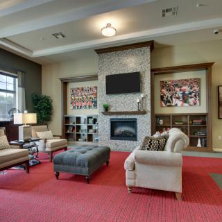 A cozy living room with a modern fireplace, comfortable seating, and decorative artwork.