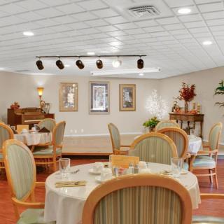 A well-decorated dining area with tables and chairs, featuring warm lighting and elegant decor.