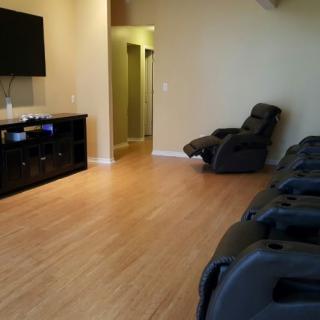 A relaxing lounge equipped with massage chairs and a television.