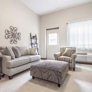 A modern living room with neutral-colored furniture and stylish decor.
