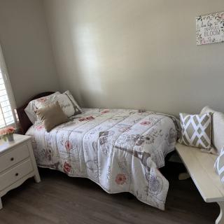 Cozy bedroom with a bed, nightstand, and decorative pillows.