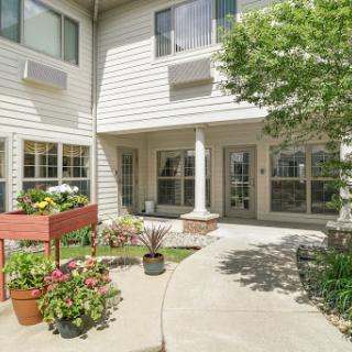 A beautifully landscaped courtyard featuring vibrant flowers and plants, surrounded by modern residential buildings.
