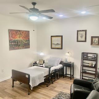 A cozy living area featuring a blend of modern and classic decor, including artwork on the walls and comfortable seating.