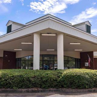 The front entrance of a building featuring tall columns and well-maintained landscaping.
