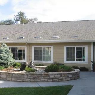 A single-story residential building with a landscaped front yard.
