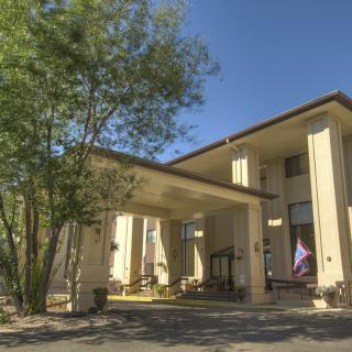 Exterior view of a hotel building with surrounding trees during the day.