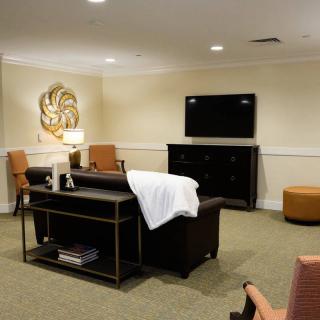 A cozy living room with modern furniture and a large television.