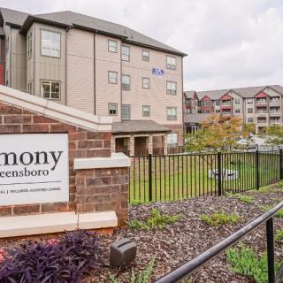 An exterior view of a residential apartment building with a sign in the foreground.