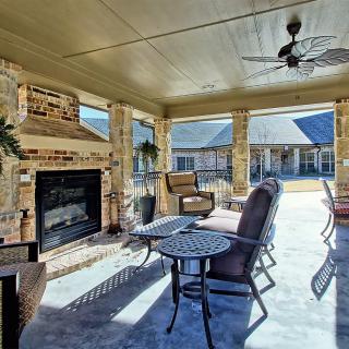 A cozy outdoor patio with a fireplace and comfortable seating arrangement.